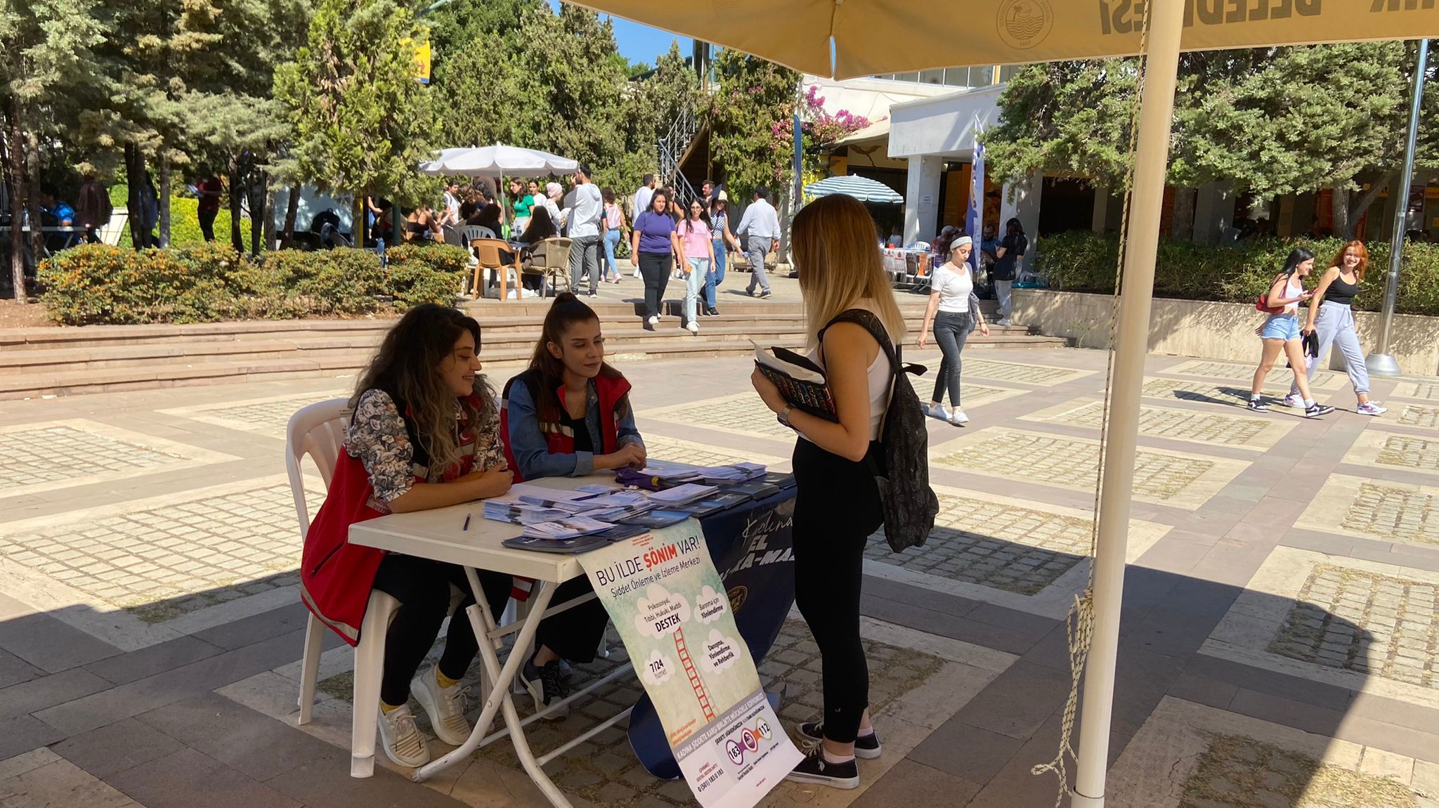 Mersin ŞÖNİM tarafından Mersin Üniversitesi Cumhuriyet alanında "Kadına Yönelik Şiddetle Mücadele" kapsamında stand açılarak Alo183 ve KADES uygulamaları konularında broşür dağıtıldı. - fotoğraf 1